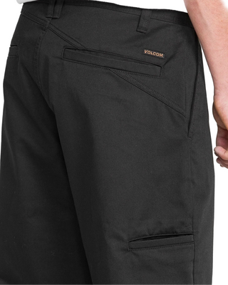 Black pants with Volcom logo on a light gray background