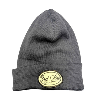 Navy beanie with a logo on a gray surface