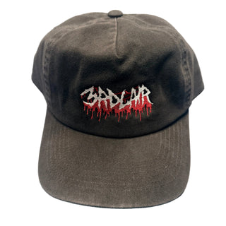 Brown cap with red and white text on a textured surface