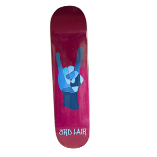 Pink skateboard deck with blue hand gesture design against a gray wall.