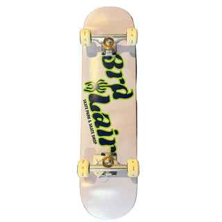 A white skateboard deck with a large green and black 'Bird Lair' graphic, resting on a dark gray concrete floor.