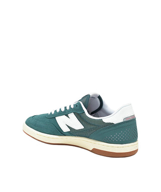 Green sneaker with white accents on a white background
