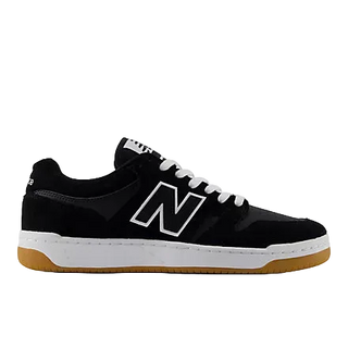 A black New Balance sneaker with a white 'N' logo, white laces, and a white midsole with a gum brown outsole, shown in a side profile on a white background.
